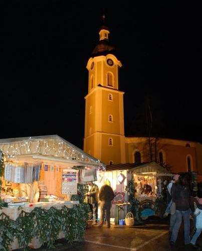 a building with a clock tower with a market in front of it at Hotel Bergblick in Scheidegg