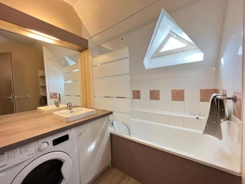 une salle de bain avec une machine à laver et un lavabo dans l'établissement T3 rénové avec balcon, vue montagne et Parking., à Cauterets