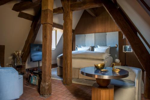 a bedroom with a bed and a table at Cour des Vosges - Evok Collection in Paris