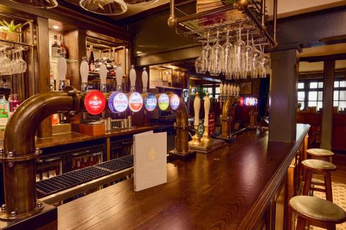 a pub with a bar with a counter with bar stools at Salisbury Arms Hotel in Hertford