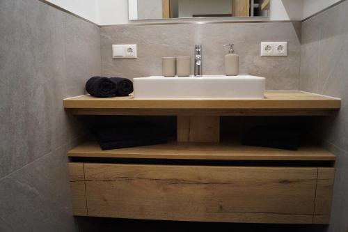 a bathroom with a sink on a wooden counter at Ferienwohnung Julia Pillerseetal in Fieberbrunn