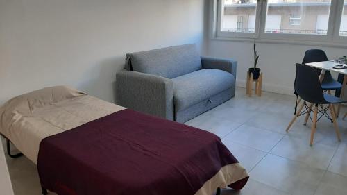 1 dormitorio con 1 cama, 1 silla y 1 mesa en Depto monoambiente nuevo reciclado, excelente ubicación Alberti 2208 en Mar del Plata