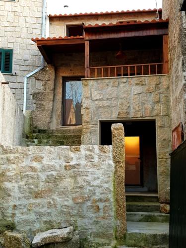 a stone house with a window and stairs in front of it at Casa Frade in Sabugueiro