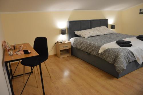 1 dormitorio con 1 cama, 1 mesa y 1 silla en ApartEłk - apartament w Ełku, en Ełk