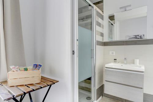 ein Bad mit einem Waschbecken und einem Spiegel in der Unterkunft Santi Quattro Apartment & Rooms - Colosseo in Rom