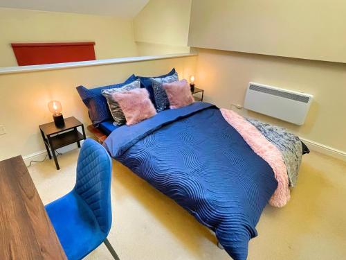 a bedroom with a blue bed and a blue chair at Centrally Located Loft Apartment in Sheffield