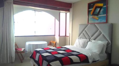 sypialnia z łóżkiem z kocem szachowym w obiekcie Bellavista w mieście Lima
