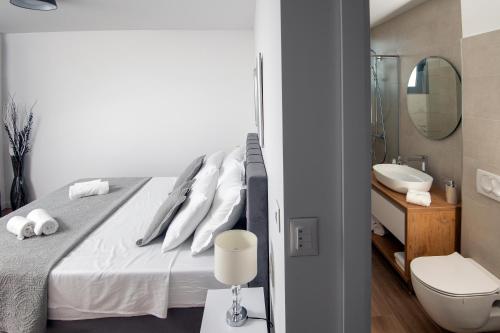 a bedroom with a bed and a bathroom with a sink at Villa Godimento w heated pool in Kučine