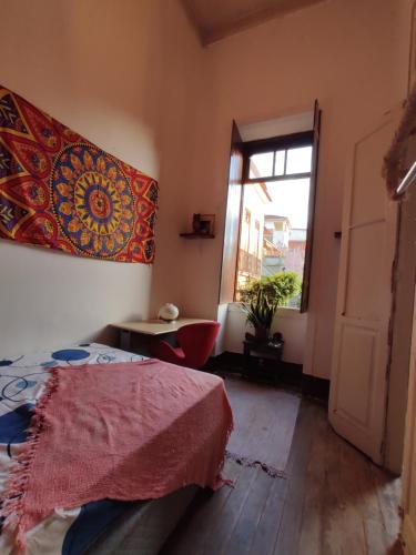 1 dormitorio con cama y ventana en Casarão artístico em Santa Teresa, en Río de Janeiro