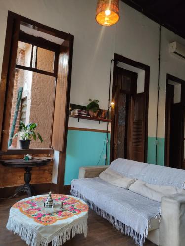 a room with two beds and a table in it at Casarão artístico em Santa Teresa in Rio de Janeiro