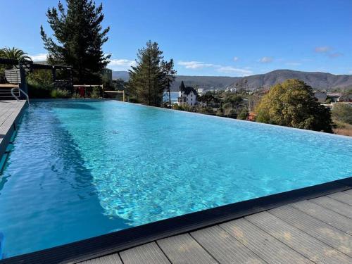 una gran piscina azul con terraza de madera en Hermoso departamento en Papudo con Vista, en Papudo