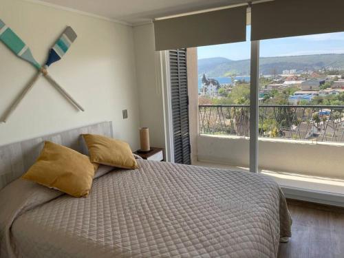 1 dormitorio con cama grande y ventana grande en Hermoso departamento en Papudo con Vista, en Papudo