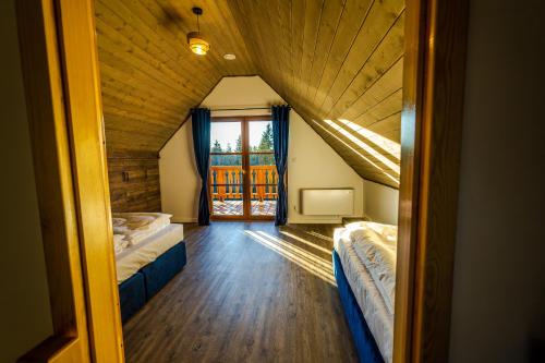 a attic room with two beds and a window at Wierchy Beskidu in Dobra