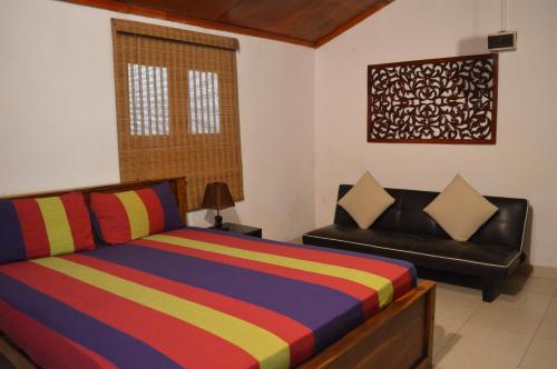 哈普塔拉的住宿－The Cottage at Galapitiyaya Estate for 6，一间卧室配有一张床和一张皮沙发