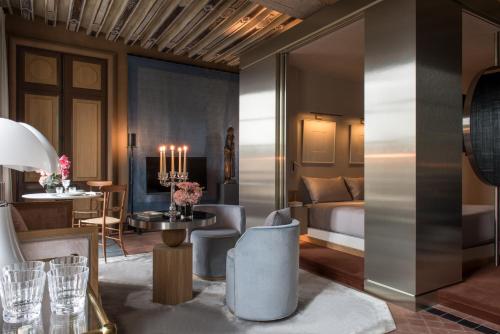 パリにあるCour des Vosges - Evok Collectionのベッド、テーブル、椅子が備わるホテルルームです。