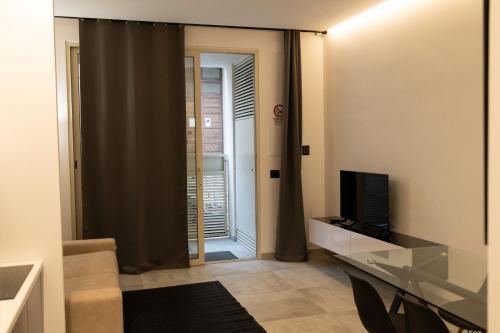 ein Wohnzimmer mit einem Glasschreibtisch und einem Fenster in der Unterkunft Eugenio suite Lecce in Lecce
