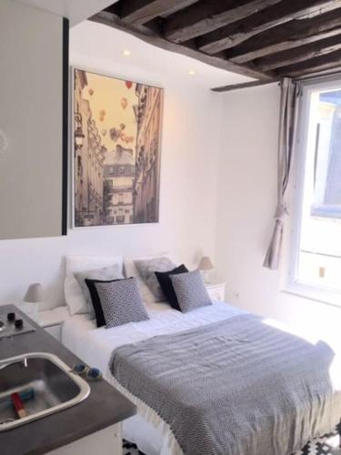 - une chambre blanche avec un lit et un lavabo dans l'établissement So cute typical french apartment (46), à Paris