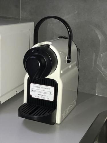 un grille-pain noir et blanc assis au-dessus d'un comptoir dans l'établissement So cute typical french apartment (46), à Paris