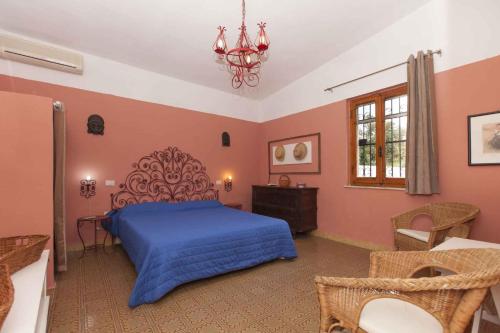 Holiday home in Torre delle Stelle 22926 في توري ديل ستيل: غرفة نوم بسرير ازرق وثريا
