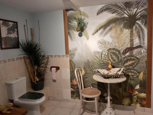 baño con aseo y plantas en la pared en O Tour du Monde, en Cellettes