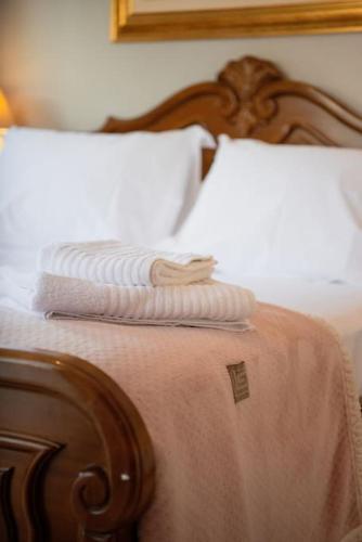 a wooden bed with two white pillows on it at Villa Valentina in Kala Nera