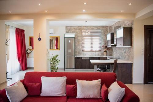 a living room with a red couch and a kitchen at Villa Valentina in Kala Nera