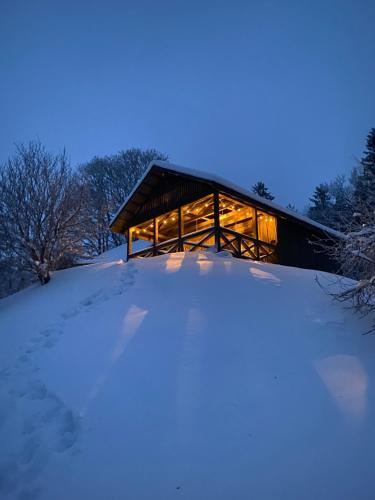 a cabin in the snow at night at Dzirnavkalns in Cesvaine