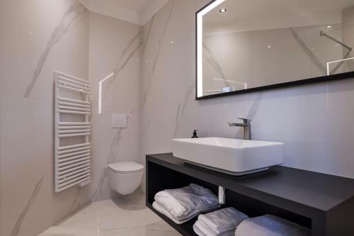 une salle de bain blanche avec un lavabo et des toilettes dans l'établissement Appartement Rooftop Chamonix, à Chamonix-Mont-Blanc