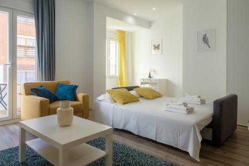 a bedroom with a bed and a chair and a table at Modern, Stylish Apartment with balcony in Valencia