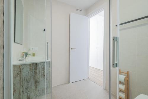 a bathroom with a glass shower and a sink at Modern, Stylish Apartment with balcony in Valencia