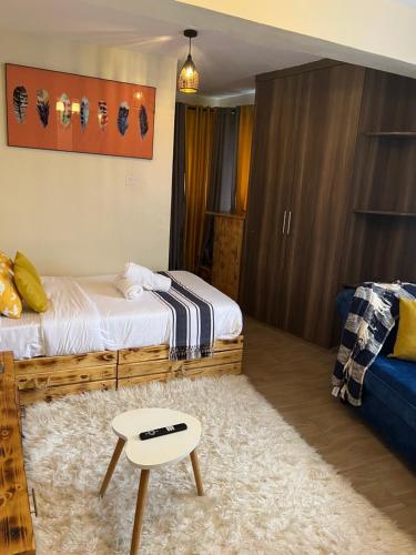 a bedroom with a bed and a table in it at Ruby Modern Homes Studio-Imara Daima,Behind Imaara Mall-JKIA-Horizon in Nairobi