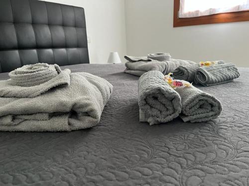 un letto con sopra un mucchio di asciugamani di La casa di Chicca a Noventa
