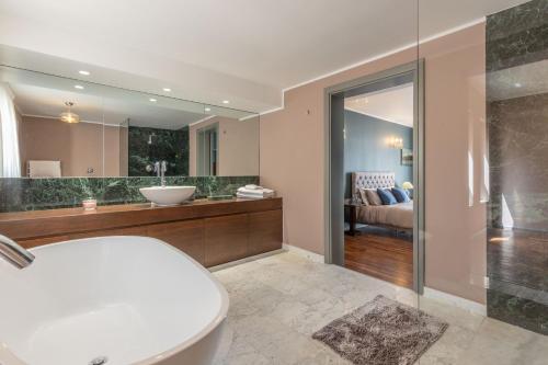 Stylish Valletta Apartment With Spectacular Views في فاليتا: حمام مع حوض ومغسلة ومرآة