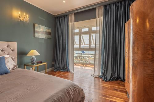Stylish Valletta Apartment With Spectacular Views في فاليتا: غرفة نوم بسرير ونافذة كبيرة