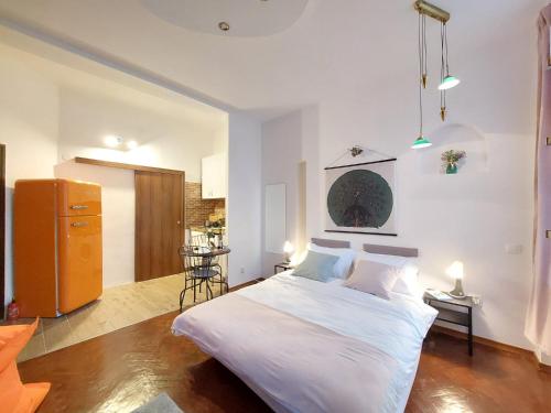 Un dormitorio con una gran cama blanca y una mesa en Sweet Dreams Suites Cosy Studio Piata Romana en Bucarest