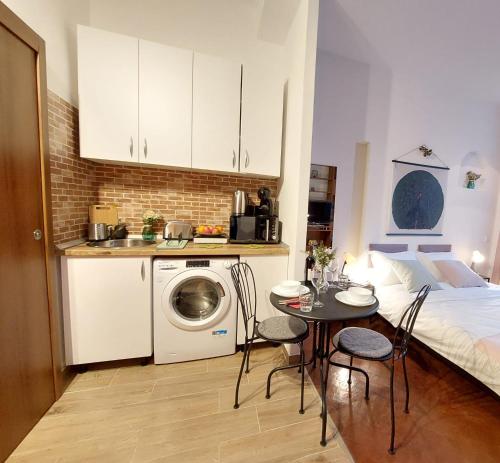 a kitchen with a bed and a table with chairs at Sweet Dreams Suites Cosy Studio Piata Romana in Bucharest