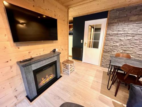 a living room with a fireplace and a flat screen tv at Centre station 1800 - 2 Chambres - Vue panoramique in Les Orres