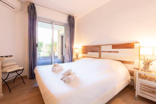 een slaapkamer met een groot wit bed met handdoeken erop bij Paradise Cannes Center with Pool and Park VILLA LE LYS in Cannes