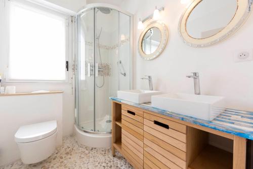 a bathroom with two sinks and a shower and a toilet at Paradise Cannes Center with Pool and Park VILLA LE LYS in Cannes