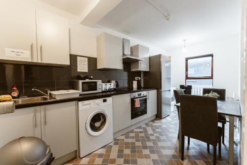 a kitchen with a sink and a washing machine at Whitechapel en-suite beds to stay in London