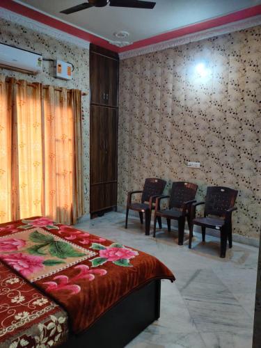 a bedroom with a bed and chairs in it at Stayvilla - Private Bungalow in Jammu in Jammu