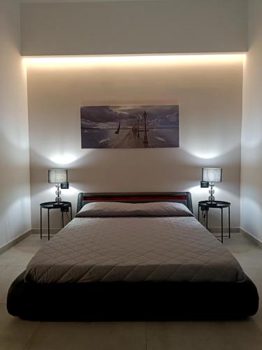 ein Schlafzimmer mit zwei Lampen auf beiden Seiten eines Bettes in der Unterkunft Eugenio suite Lecce in Lecce