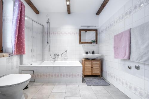uma casa de banho com uma banheira, um WC e um lavatório. em Haus Hohenwiesen em Lenggries