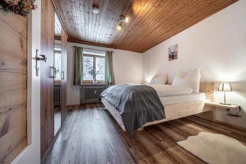 1 dormitorio con cama y techo de madera en Haus Hohenwiesen en Lenggries