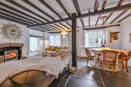 a bedroom with a bed and a table and a fireplace at Briardene Cottage - A Superb Bijou Retreat with Jacuzzi near an Excellent Village Pub in Yelverton
