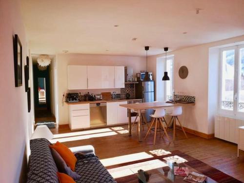 sala de estar y cocina con sofá y mesa en ® Le Mexicain - Superbe T3 / Barcelonnette centre en Barcelonnette
