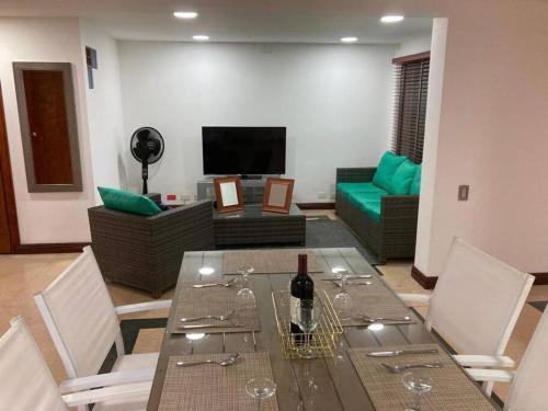 uma sala de estar com uma mesa e uma garrafa de vinho em Departamento Cerca a la Terminal del Sur MAG201 em Medellín