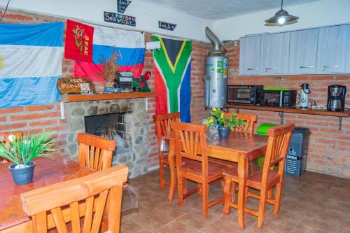 a dining room with a table and chairs and a fireplace at Posada Tinktinkie in Santa Rosa de Calamuchita