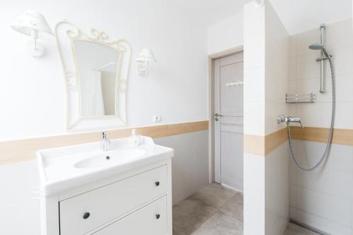 a white bathroom with a sink and a shower at Villa Mila in Mikołajki