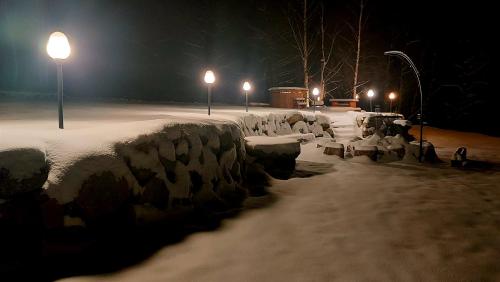 a row of benches covered in snow at night at Domek nad Czerwienią in Przesieka